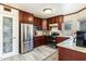 Modern kitchen with stainless steel appliances, granite countertops, mosaic backsplash, and cherry wood cabinetry at 4715 E Carmen St, Phoenix, AZ 85044