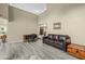 Spacious living room with high ceilings, wood-style tile flooring, a leather sofa, and a quaint work-from-home setup at 4715 E Carmen St, Phoenix, AZ 85044
