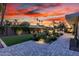 Tranquil backyard with lush greenery, paved patio and ambient lighting against a vivid sunset at 4835 E Onyx Ave, Paradise Valley, AZ 85253