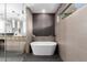 Luxurious bathroom featuring a freestanding tub, tiled accent wall, and modern fixtures at 4835 E Onyx Ave, Paradise Valley, AZ 85253