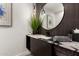 Modern powder room features a round mirror and granite countertop at 4835 E Onyx Ave, Paradise Valley, AZ 85253