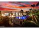 Resort-style pool with water feature, tiki torches, and modern architecture under a colorful sky at 4835 E Onyx Ave, Paradise Valley, AZ 85253