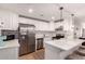 Modern kitchen featuring stainless steel appliances, white cabinets, and quartz countertops with breakfast bar seating at 4950 N Miller Rd # 200, Scottsdale, AZ 85251