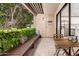 Charming patio area with wood bench, table, greenery and access to the inside of the condo at 4950 N Miller Rd # 200, Scottsdale, AZ 85251
