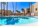 Community pool surrounded by tall palm trees offering shaded spots for relaxation and sunbathing at 4950 N Miller Rd # 200, Scottsdale, AZ 85251
