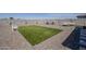 Beautiful backyard featuring synthetic grass lawn, gravel groundcover, patio furniture, and a privacy wall at 5048 N 84Th Dr, Glendale, AZ 85305