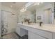Bright bathroom with double sinks, white vanity, and shower-tub combo at 5048 N 84Th Dr, Glendale, AZ 85305