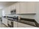 Well-lit kitchen boasts ample counter space, white cabinets, and stainless steel appliances at 5048 N 84Th Dr, Glendale, AZ 85305