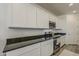 Modern kitchen features white cabinets, dark countertops, and stainless steel appliances at 5048 N 84Th Dr, Glendale, AZ 85305