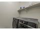 Laundry room with a modern Samsung washer and dryer, and a shelf for storage at 5048 N 84Th Dr, Glendale, AZ 85305