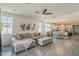 Open-concept living room with gray sectional sofa and tile flooring flowing into kitchen area at 5048 N 84Th Dr, Glendale, AZ 85305