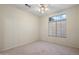 Bright bedroom featuring neutral carpet, ceiling fan, and well-lit natural light from a window at 530 N Jesse Ct, Chandler, AZ 85225
