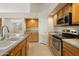 Well-lit kitchen featuring stainless steel appliances, light wood cabinets, and a tiled floor at 530 N Jesse Ct, Chandler, AZ 85225