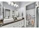 Bright bathroom with dual sinks, dark countertops, and a shower with a colorful floral curtain at 5537 E Dusty Wren Dr, Cave Creek, AZ 85331
