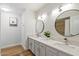Bright bathroom with dual sinks, stylish lighting, and a decorative framed art print at 6271 E Evans Dr, Scottsdale, AZ 85254