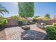 Serene backyard patio with brick pavers, mature trees, and an outdoor dining set shaded by an umbrella at 6397 S Pinaleno Pl, Chandler, AZ 85249