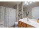 Bright bathroom featuring a single sink vanity, decorative shelves, and a shower with a leafy patterned curtain at 6397 S Pinaleno Pl, Chandler, AZ 85249