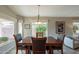 Well-lit dining area with a wooden table, modern chandelier, and view of the outdoor scenery at 6397 S Pinaleno Pl, Chandler, AZ 85249