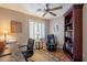 Cozy home office with hardwood floors, ceiling fan, built-in bookcase, and comfortable seating area at 6397 S Pinaleno Pl, Chandler, AZ 85249