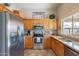 Well-lit kitchen features stainless steel appliances, light wood cabinets, and neutral countertops at 6397 S Pinaleno Pl, Chandler, AZ 85249