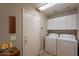 Functional laundry room featuring a washer, dryer, storage cabinets, and convenient access door at 6397 S Pinaleno Pl, Chandler, AZ 85249