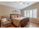This is a well-lit main bedroom with a wooden bed frame, neutral walls, and a ceiling fan at 6397 S Pinaleno Pl, Chandler, AZ 85249