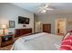 Inviting main bedroom featuring a wooden bed frame, a ceiling fan, and a wall-mounted TV at 6397 S Pinaleno Pl, Chandler, AZ 85249