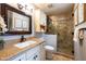 Well-lit bathroom featuring a vanity with counter, enclosed glass shower, and toilet at 6526 N 13Th Dr, Phoenix, AZ 85013