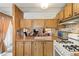 Compact kitchen with wood cabinets, practical appliances, and an open view to living area at 701 S Dobson Rd # 259, Mesa, AZ 85202