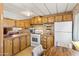 Functional kitchen with wood cabinetry, white appliances, and a cozy breakfast nook at 701 S Dobson Rd # 259, Mesa, AZ 85202