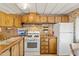 Efficient kitchen layout featuring ample cabinet space, white appliances, and vintage wallpaper at 701 S Dobson Rd # 259, Mesa, AZ 85202