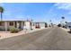Mobile homes line a street in a well-maintained community under a clear, sunny sky at 701 S Dobson Rd # 259, Mesa, AZ 85202