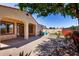 Expansive backyard with paved patio, lawn, mature trees, and desert landscaping at 7159 S Dodane Ct, Gilbert, AZ 85298