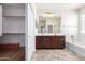 Bathroom boasts double sinks, bathtub, and walk-in shower with wood cabinets and tile flooring at 7159 S Dodane Ct, Gilbert, AZ 85298
