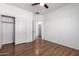 Bedroom shows wood floors, a ceiling fan, closet with slider doors, and leads to bathroom at 7159 S Dodane Ct, Gilbert, AZ 85298