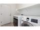Well-equipped laundry room features modern washer and dryer, and convenient shelving at 7159 S Dodane Ct, Gilbert, AZ 85298