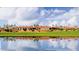 Beautiful clubhouse reflected on calm waters with palm trees and expansive green lawn at 7159 S Dodane Ct, Gilbert, AZ 85298