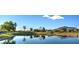 Picturesque view of a serene pond with a lush green golf course and mountain backdrop at 7159 S Dodane Ct, Gilbert, AZ 85298