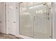 Modern shower with glass door and a tiled bench in the ensuite bathroom at 7234 S 28Th Ln, Phoenix, AZ 85041