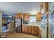 Galley kitchen featuring wood cabinets, with adjacent living space at 7318 E Arbor Ave, Mesa, AZ 85208