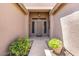 Inviting covered front entry featuring sidelight windows and decorative plants at 7778 N 51St Ln, Glendale, AZ 85301