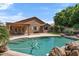 Backyard view of the private in-ground pool with rock features and well-maintained landscaping at 7778 N 51St Ln, Glendale, AZ 85301