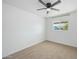 Bright bedroom features neutral carpet, a ceiling fan, and natural light from the window at 843 N Evergreen St, Chandler, AZ 85225
