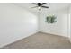 Bright bedroom featuring neutral carpet, a ceiling fan, and natural light from the window at 843 N Evergreen St, Chandler, AZ 85225