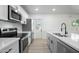 Charming kitchen equipped with stainless appliances, quartz countertops and easy access to the backyard at 843 N Evergreen St, Chandler, AZ 85225