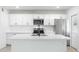 Close-up of a modern kitchen with stainless steel appliances, white cabinetry, and a quartz countertop island at 843 N Evergreen St, Chandler, AZ 85225