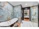 Charming bathroom with freestanding tub, elegant fixtures, and a glass enclosed shower with marble walls at 87 W Windsor Ave, Phoenix, AZ 85003