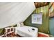 Cozy bedroom with an angled ceiling, natural light, and a vintage bedside table at 87 W Windsor Ave, Phoenix, AZ 85003