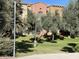Well-maintained grounds featuring mature trees, green grass and landscaping surrounding residential buildings under a clear blue sky at 900 S 94Th St # 1166, Chandler, AZ 85224