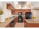 Well-lit kitchen features an island, sleek black appliances, and warm-toned cabinetry at 900 S 94Th St # 1166, Chandler, AZ 85224